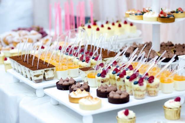 Candy bar with macarons, cakes, cake pops, close up.