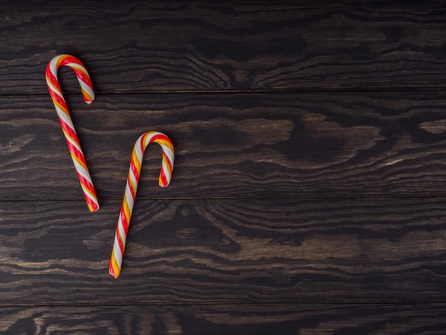 Candy cane on an old wooden table. Christmas background. Christmas, New Year holiday background. Flat-lay of greeting card over wooden table, top view