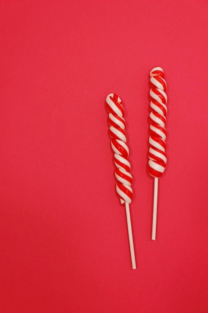 빨간색 배경에 파티 디자인을 위한 사탕 지팡이. 크리스마스 구성입니다. 평평한 평지, 평면도.