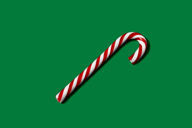 Photo candy cane striped in christmas colors on green background.