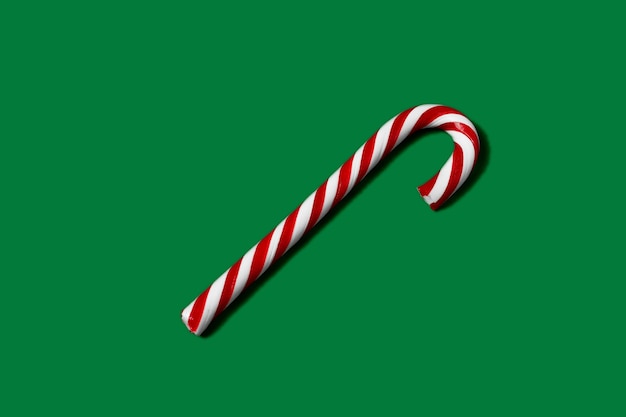사진 녹색 배경에 크리스마스 색상에 줄무늬 사탕 지팡이.