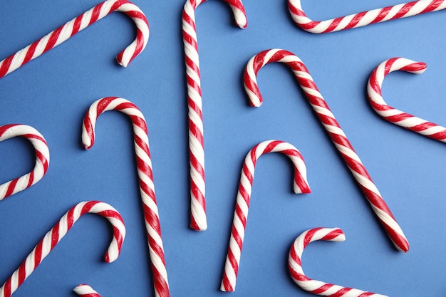 Candy canes on blue background flat lay