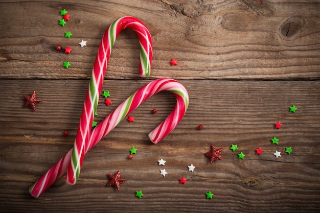 Candy canes on wooden board
