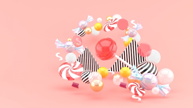 Candy among colorful balls on pink. 3d rendering.
