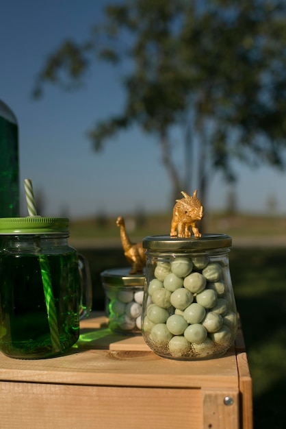 Candy in a glass jar, which is decorated with a figure of a golden dinosaur