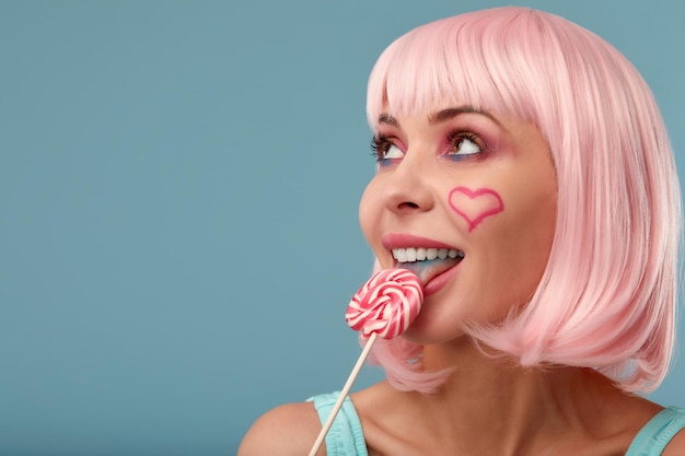 Candy Lolli pop Party Girl позирует в синей студии Ролевые игры Хэллоуин концепция сладкий любовник