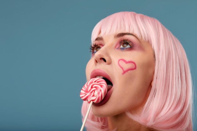 Candy Lolli pop Party Girl позирует в синей студии Ролевые игры Хэллоуин концепция сладкий любовник