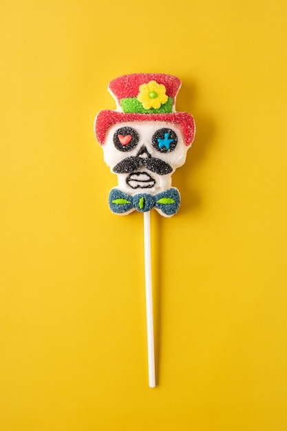 Candy Mexican skull lollipop isolated on yellow background