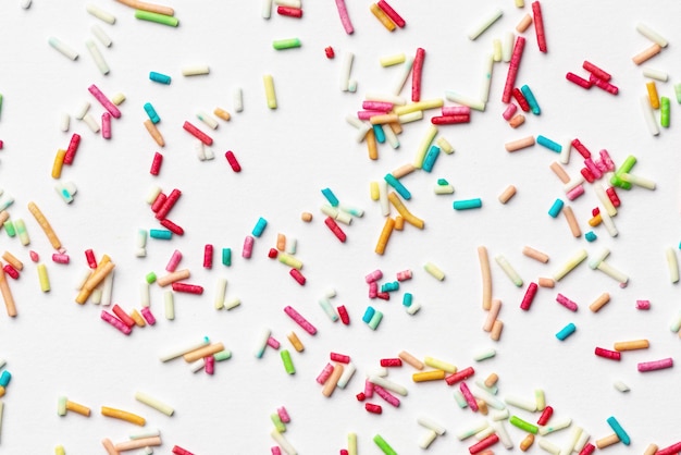 Candy multi colored sprinkles background Rainbow coloured sprinkles on white background