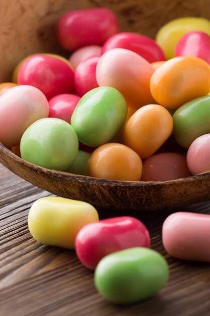 Candy pop colors bowl and wooden surface.