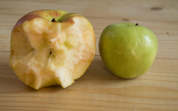 Candy and ripe green Apple on wooden background