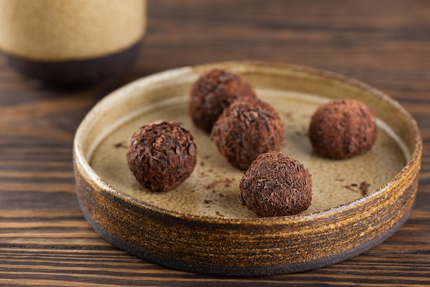 Candy truffles with chocolate on a plate on a brown wooden table brazilian sweets