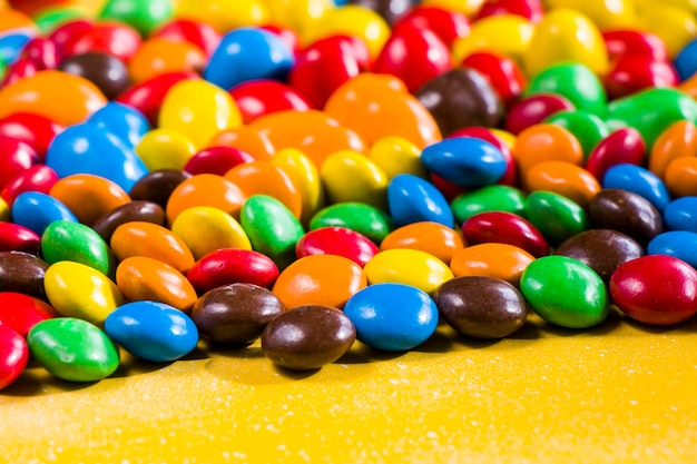 Candy on the yellow background colorful candy and multicolored gradient