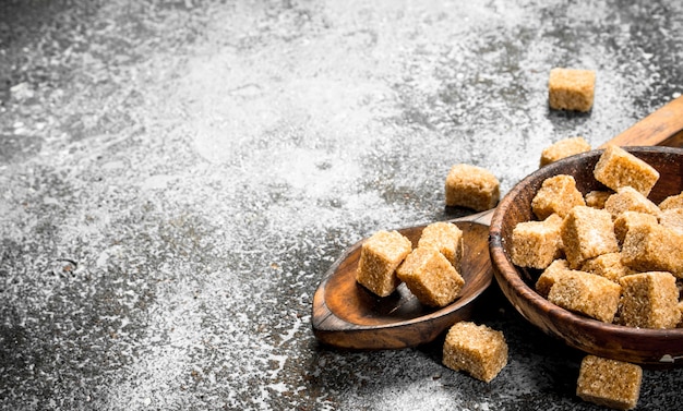 Cane sugar in a bowl. On a rustic background.