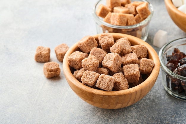 Cane sugar cube in bamboo bowl on gray table concrete