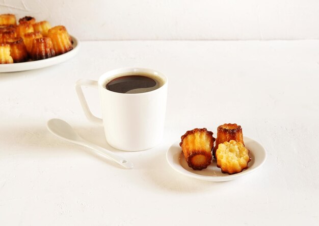 Canelle is a traditional french pastry with cup of coffee white table  morning breakfast concept copy space