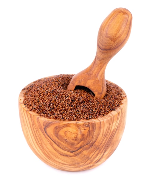 Canihua grains isolated on white background Pile of qaniwa in olive bowl and scoop Dry grains of chenopodium pallidicaule