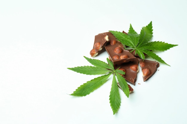 Cannabis chocolate and leaves on white