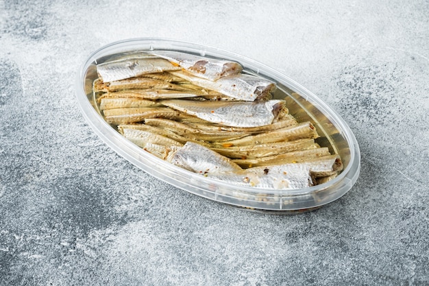 Canned Anchovy  set, in plastic container, on gray background, top view flat lay, with copyspace  and space for text