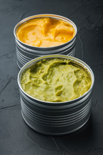 Canned cheese and guacamole  sauce in can, on black table