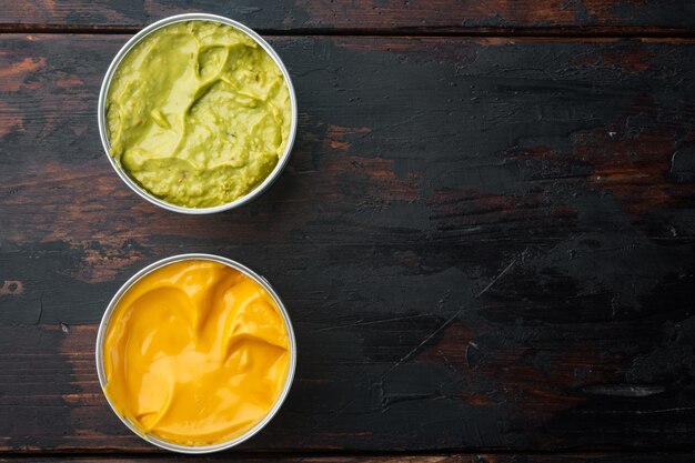 Canned cheese and guacamole  sauce in can, on old wooden table, top view or flat lay