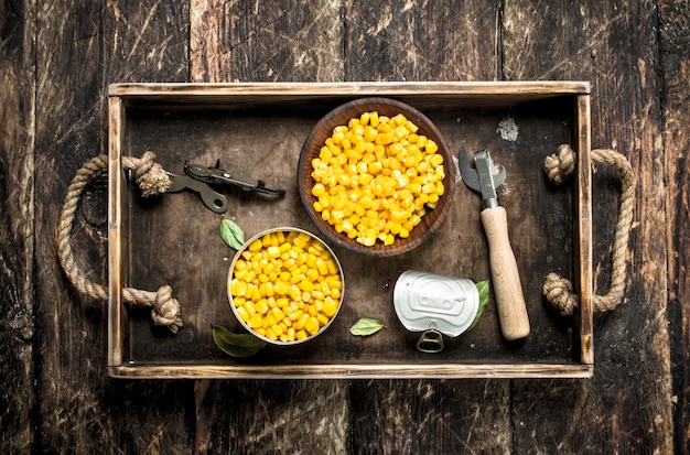 Фото Консервированная кукуруза в миске. на деревянном фоне.
