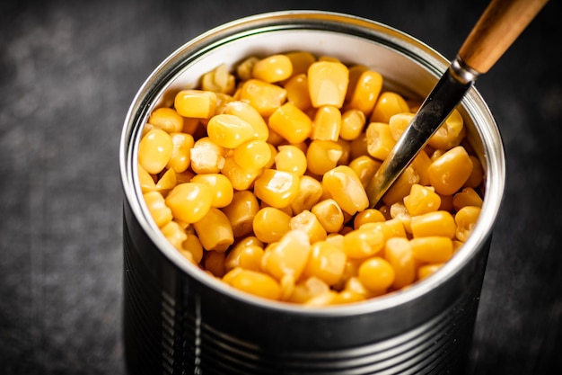 Canned corn in a tin can with a spoon