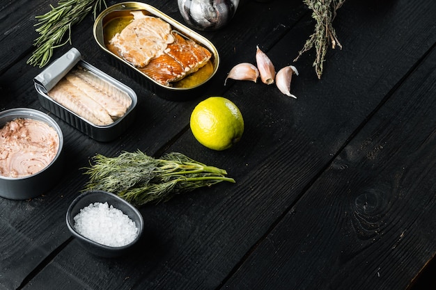 Canned fish with different assortment types of seafood set, on black wooden table