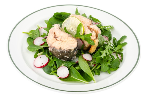 Canned fish with greens on plate isolated on white. Studio Photo