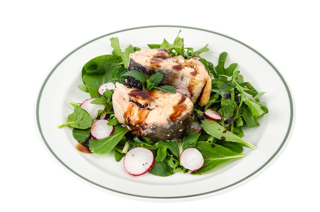 Canned fish with greens on plate isolated on white. Studio Photo