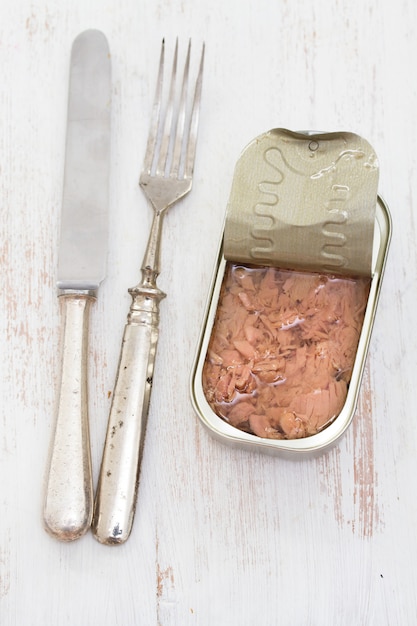 Canned fish on wooden surface