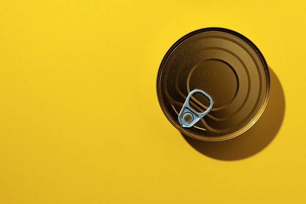 Canned food tin on yellow studio surface