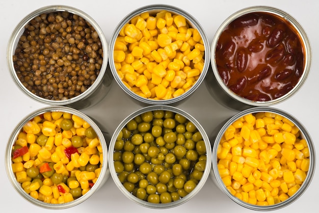 Canned food on white background. Green pea, beans, corn, lentils.