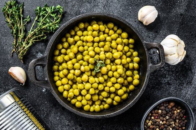 Canned green peas in a frying pan. 