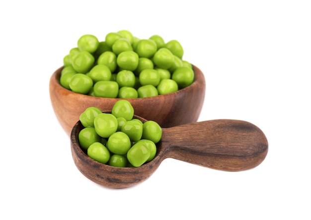 Canned green peas in wooden bowl and spoon, isolated  Pickled green peas.