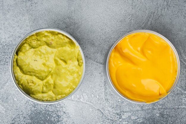 Canned guacamole and cheese dip in can, on gray table, top view or flat lay