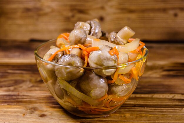 Canned mushrooms with carrot and onion in a ceramic bowl