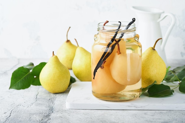 Canned pear compote with vanillin Pear compote Homemade delicious canned pear compote in glass jars at home on a light background Homemade food Space for text