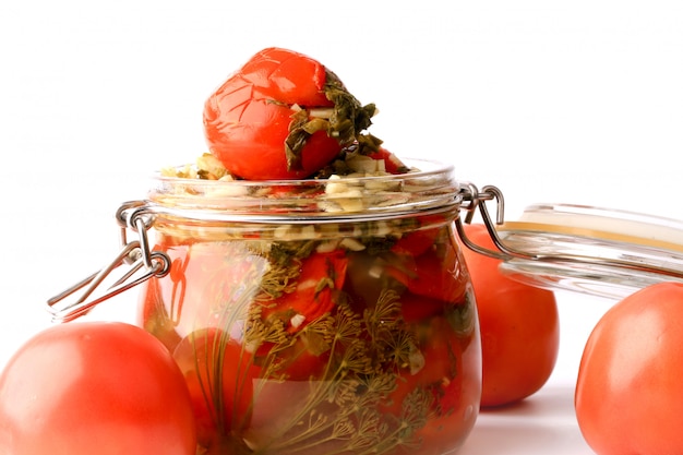 Canned pickled tomatoes in a glass jar isolated  rustic style