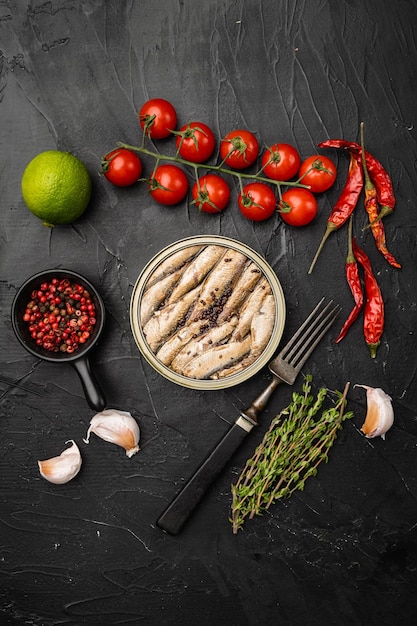 Canned sardines. Sea fish in tin can set, on black dark stone table background, top view flat lay