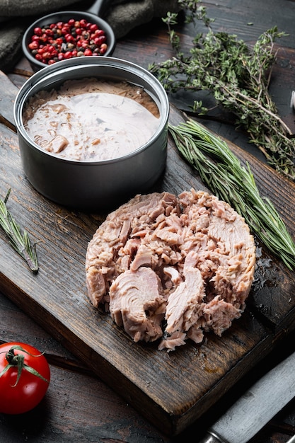 Canned soy free albacore white meat tuna, on wooden cutting board, on old dark  wooden table
