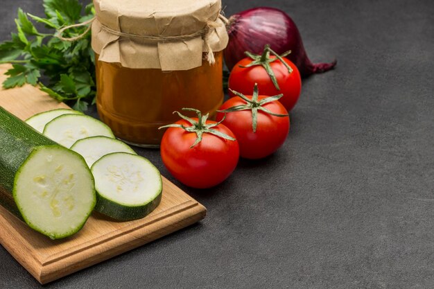 Canned squash spread in glass jar Raw vegetables and spices Black background Copy space Close up