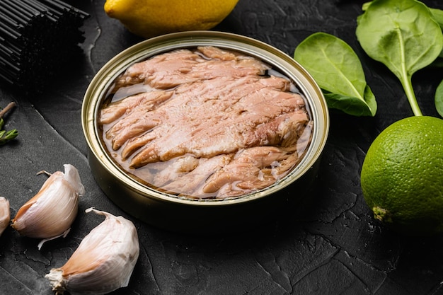 Canned tuna fish set on black dark stone table background
