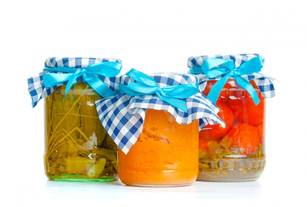 Canned vegetables in glass jars isolated on white