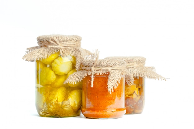 Canned vegetables in glass jars isolated on white