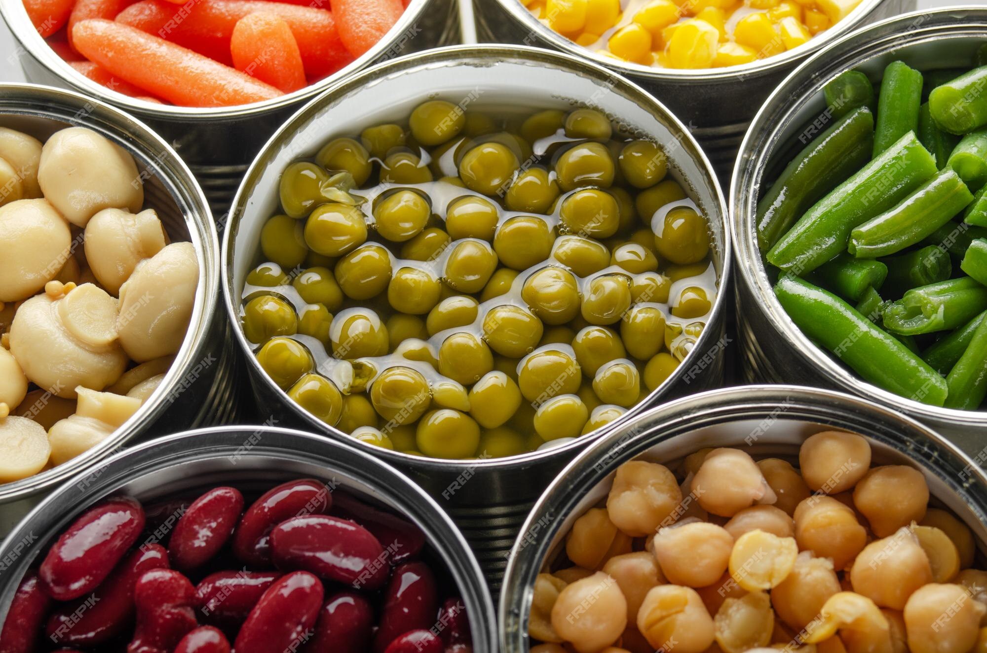 Premium Photo | Canned vegetables in opened tin cans on kitchen table ...