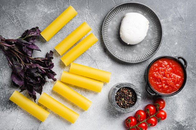 Cannelloni met ingrediënten set, op grijze stenen tafel achtergrond, bovenaanzicht plat lag