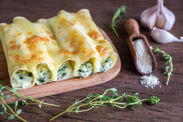 Cannelloni met ricotta en spinazie op een houten bord