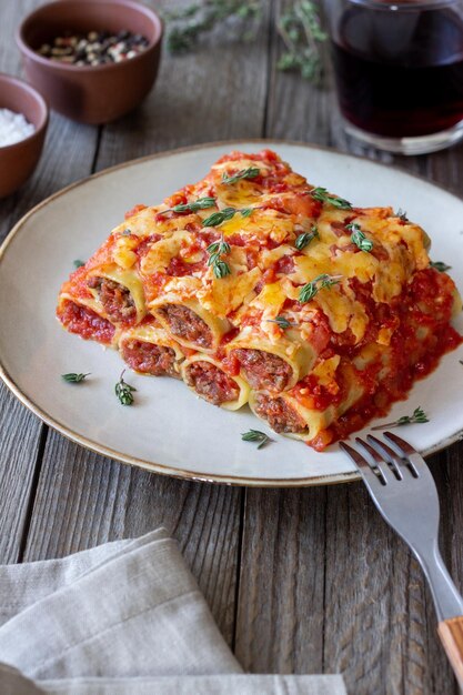 Foto cannelloni met vleeskaas, tomaten en tijm italiaanse keuken