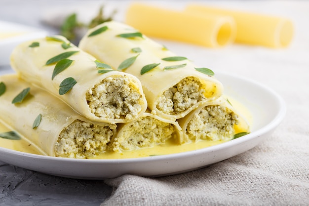 Cannelloni pasta met eiersaus, roomkaas en oregobladeren.